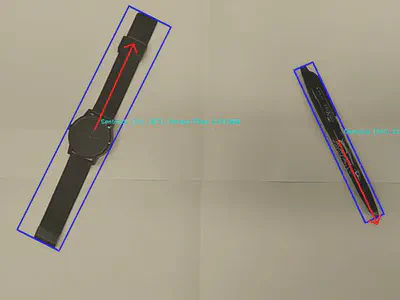 A watch and a pen segmented with oriented bounding boxes, axis-of-least-central-moment arrows, and live feature values overlaid